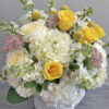 The Triumph floral arrangement features an exquisite combination of white and yellow roses,